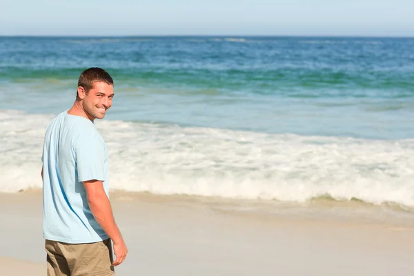 Hombre guapo caminando por la playa — Foto de Stock