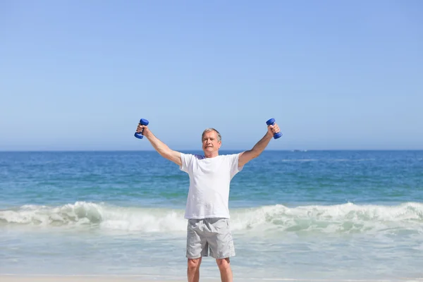 Člověk dělá jeho cvičení na pláži — Stock fotografie
