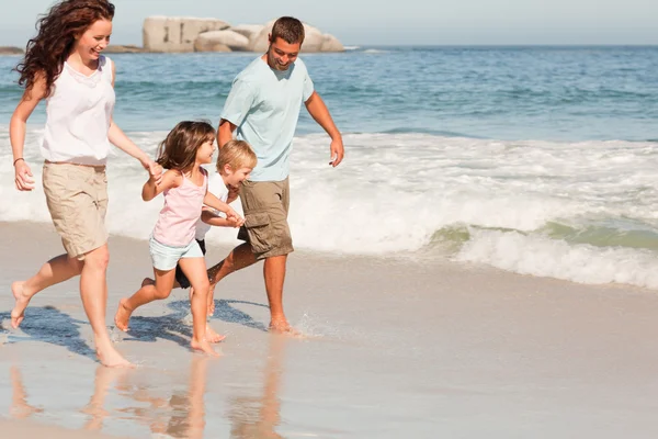Família correndo na praia — Fotografia de Stock
