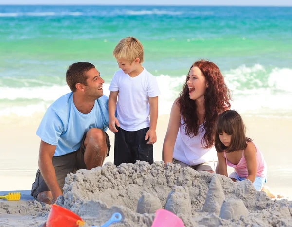 Strålande familjen på stranden — Stockfoto