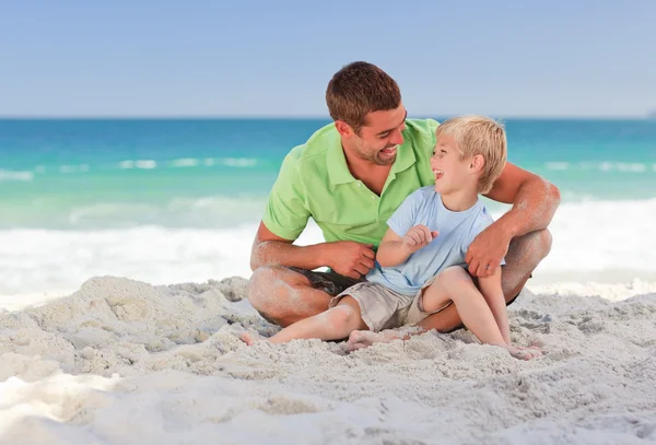 Gelukkig vader met zijn zoon op het strand — Stockfoto