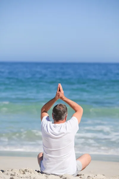 Człowiek robi jego rozciąga się na plaży — Zdjęcie stockowe