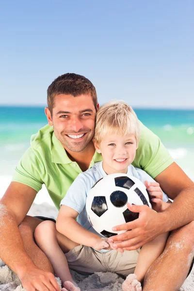 Счастливый отец играет в футбол со своим сыном — стоковое фото