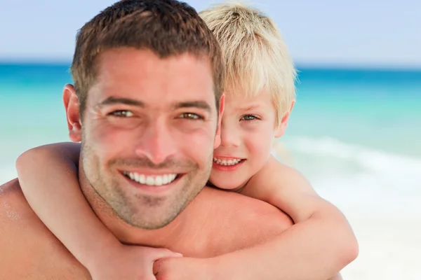 Gülümseyen baba oğlu bir sırtlama plajda sahip. — Stok fotoğraf