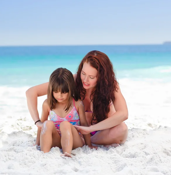 Použití sluneční krém na zádech její dcera matka — Stock fotografie