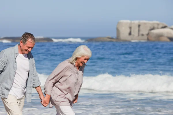 Ηλικιωμένο ζευγάρι περπάτημα στην παραλία — Φωτογραφία Αρχείου