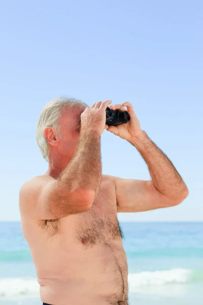 Obserwowanie ptaków starszy mężczyzna na plaży — Zdjęcie stockowe