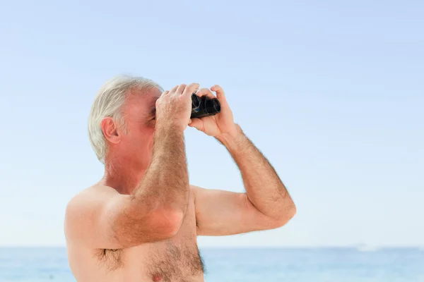 Senior man bird watching at the beach — Stock Photo, Image