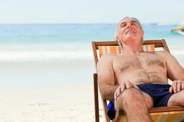 Homem deitado em sua cadeira de praia — Fotografia de Stock