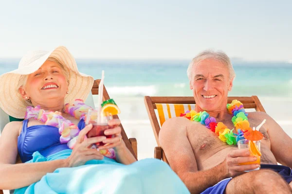 Couple drinking cocktails at the beach — Stock Photo, Image
