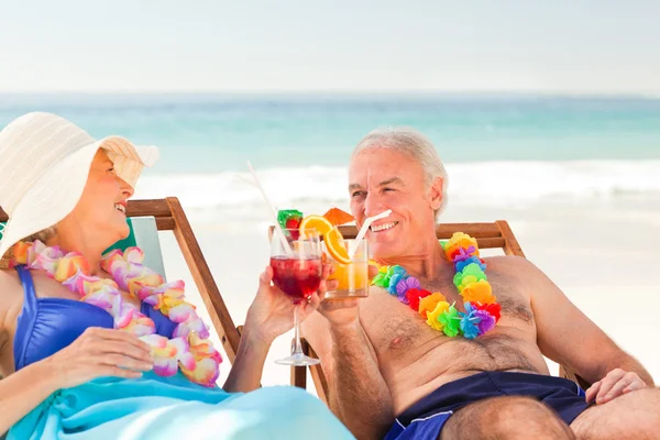Casal beber cocktails na praia — Fotografia de Stock