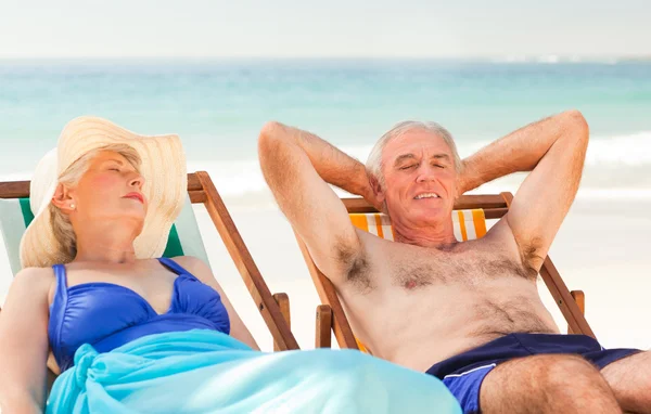 Par liggande i sina solstolar — Stockfoto