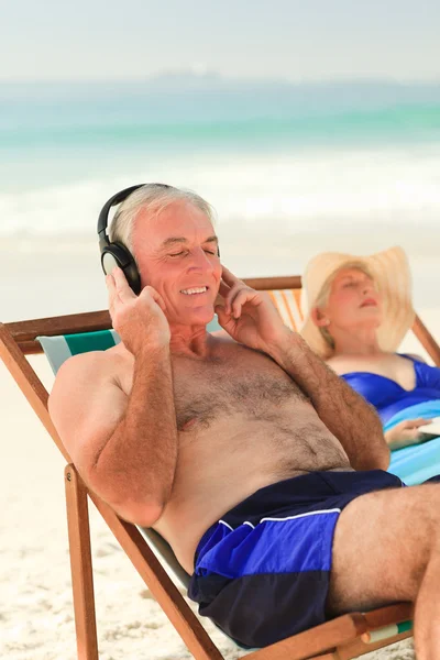 남자가 그의 아내는 자 고 있는 동안 음악을 듣고 — 스톡 사진