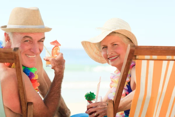 Счастливая старшая пара пьет коктейль — стоковое фото