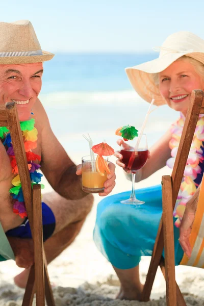 Feliz pareja mayor bebiendo un cóctel — Foto de Stock