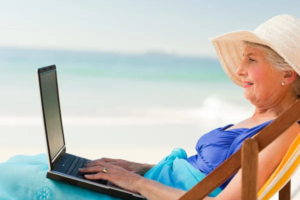 Onu laptop plajda çalışan mutlu kadın — Stok fotoğraf