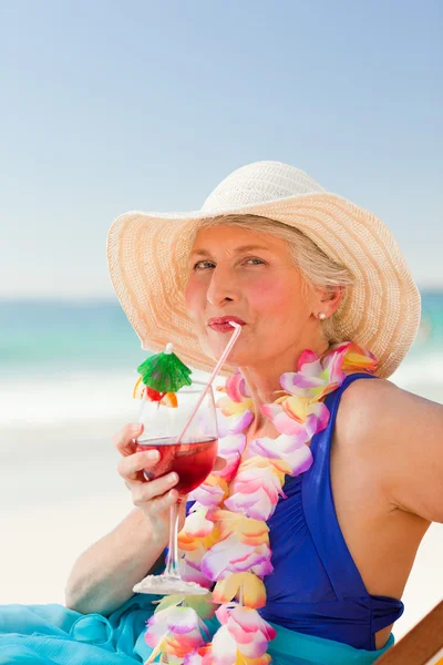 Kvinna dricka en cocktail i sin solstol — Stockfoto