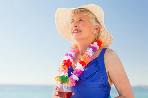 Starsza kobieta picia koktajl na plaży — Zdjęcie stockowe