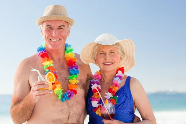Senior koppel drinken een cocktail op het strand — Stockfoto