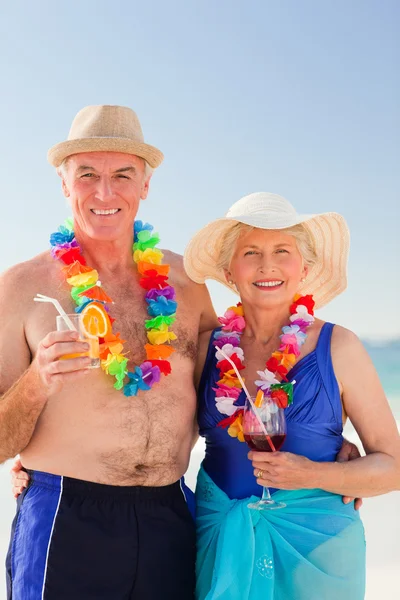 Ανώτερος ζευγάρι πίνοντας ένα κοκτέιλ στην παραλία — Φωτογραφία Αρχείου