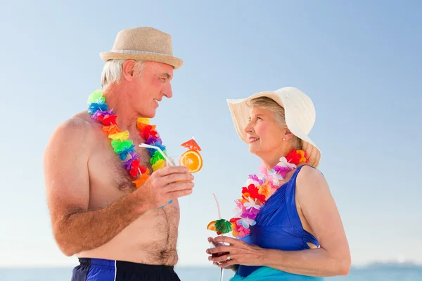Senior koppel drinken een cocktail op het strand — Stockfoto