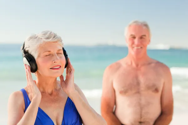 Kadın sahilde biraz müzik dinlemek — Stok fotoğraf