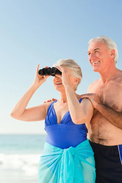 Anziani coppia bird watching in spiaggia — Foto Stock