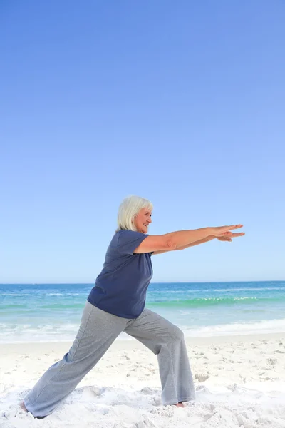 Pensionerad kvinna gör hennes sträckor — Stockfoto