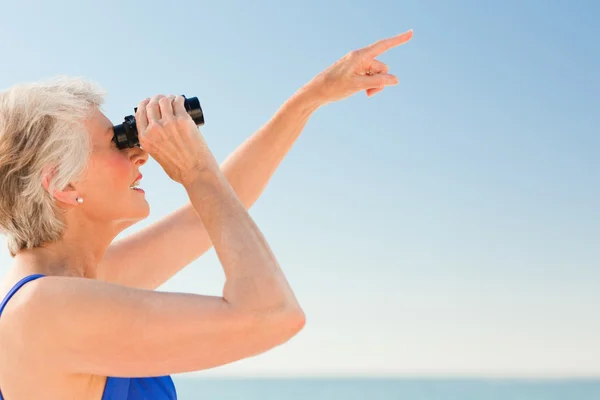 Mujer mayor observando aves en la playa —  Fotos de Stock