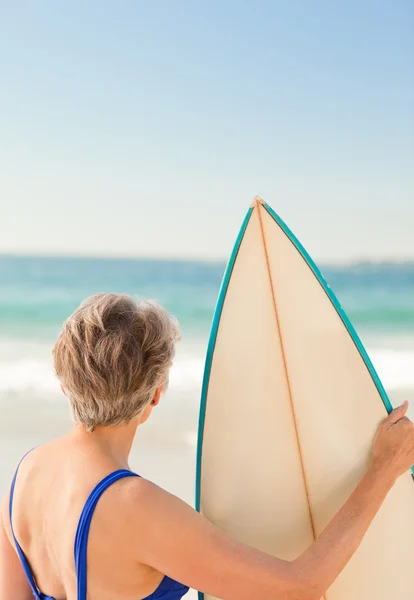 Vrouw met haar surfboard op het strand — Stockfoto