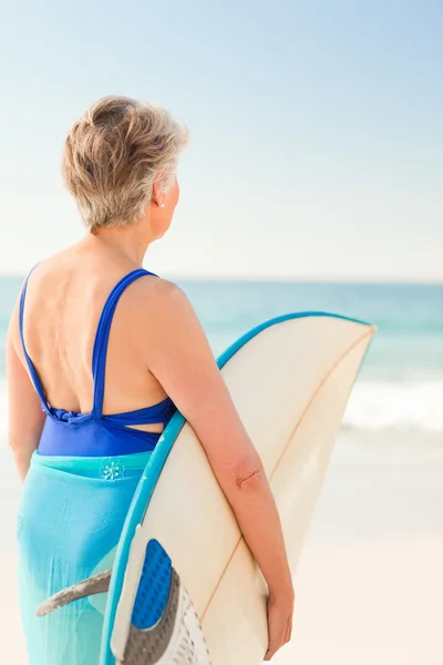 Vrouw met haar surfboard op het strand — Stockfoto