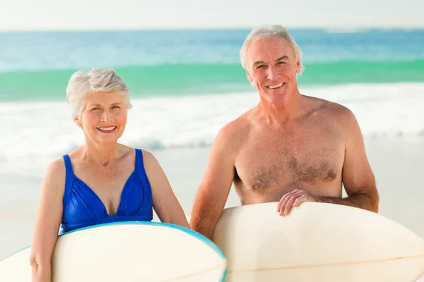 Met hun surfboard op het strand (echt) paar — Stockfoto