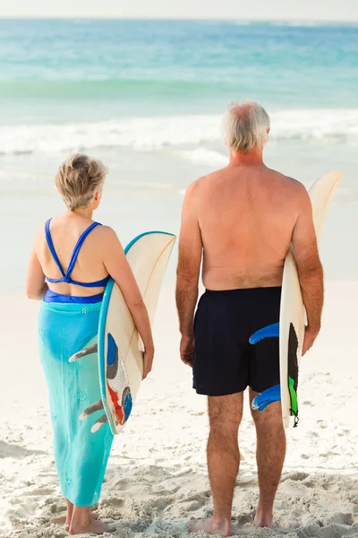Casal com sua prancha de surf na praia — Fotografia de Stock