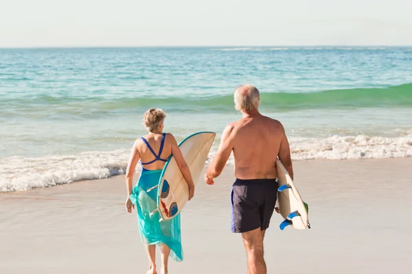 Par med deras surfbräda på stranden — Stockfoto