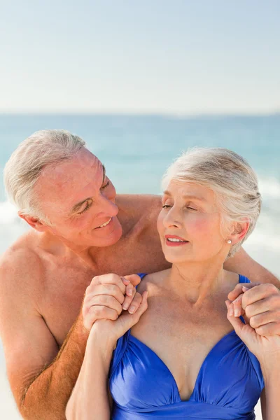 Homem abraçando sua esposa na praia — Fotografia de Stock