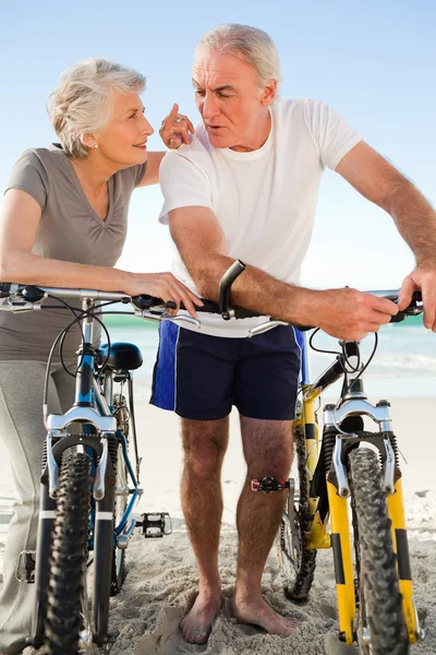 Cuplu pensionar cu bicicletele lor pe plajă — Fotografie, imagine de stoc