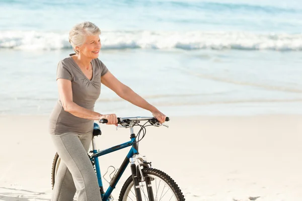 Äldre kvinna med hennes cykel — Stockfoto