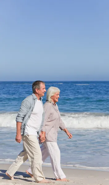 Casal de idosos caminhando na praia — Fotografia de Stock