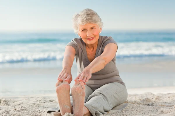 Elderly woman doing her streches — Stock Photo, Image