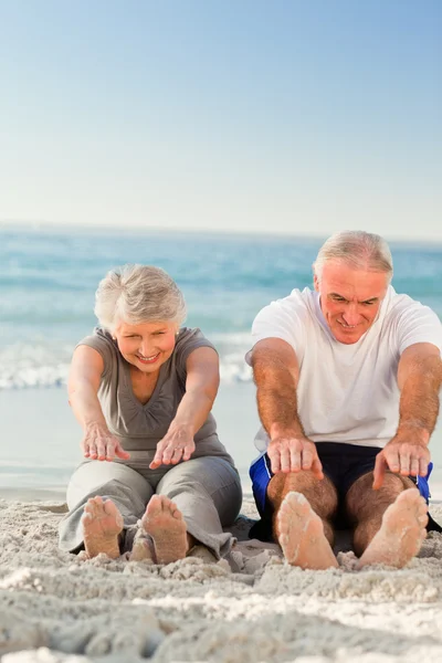 Paar beim Stretching am Strand — Stockfoto