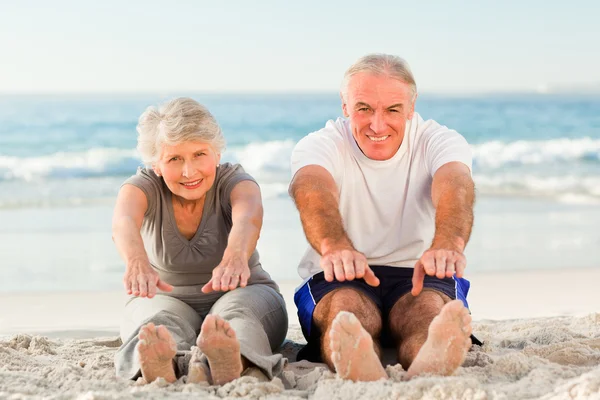 Paar beim Stretching am Strand — Stockfoto