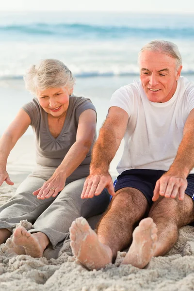 Couple doing their streches at the beach — Stock Photo, Image