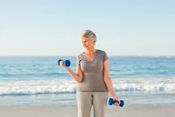 Mulher fazendo seus exercícios na praia — Fotografia de Stock