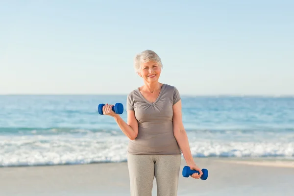 Mujer haciendo sus ejercicios en la playa —  Fotos de Stock