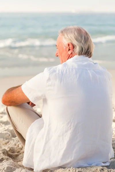 Man zittend op het strand — Stockfoto