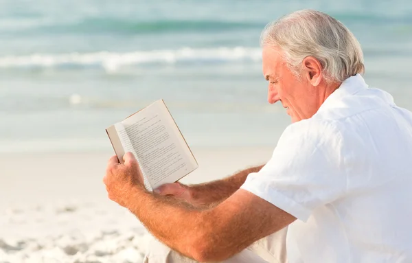 Mann liest ein Buch am Strand — Stockfoto