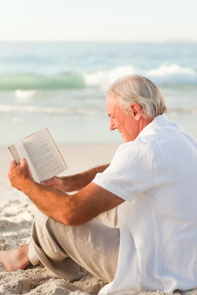 Man reading a book on the beach — Stock Photo, Image