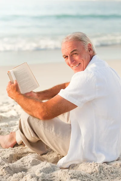 Adam sahilde kitap okuma — Stok fotoğraf