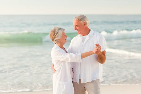 Bejaarde echtpaar dansen op het strand — Stockfoto