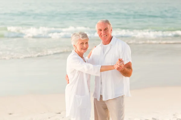 Bejaarde echtpaar dansen op het strand — Stockfoto